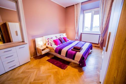 Schlafzimmer mit einem Bett und einem Fenster in der Unterkunft Market Square Residence in Krakau