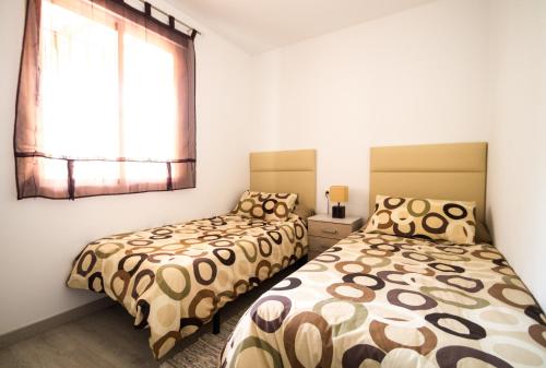 オリフエラ・コスタにあるPerfect Family Retreat - La Zenia Beachのベッドルーム1室(ベッド2台、窓付)