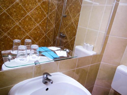 a bathroom with a sink and a mirror at Classic Hotel in Budapest