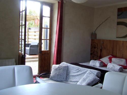 LanvallayにあるO Bois Dormant- Studio Vue Rance River et viaduc de DINANのベッドルーム1室(ベッド2台、テーブル、椅子付)
