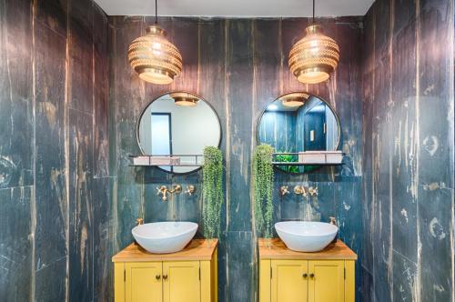 a bathroom with two sinks and two mirrors at Eldan Hotel in Jerusalem