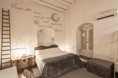 a bedroom with a bed and a sign on the wall at Locanda Don Serafino Historical Boutique Hotel in Ragusa