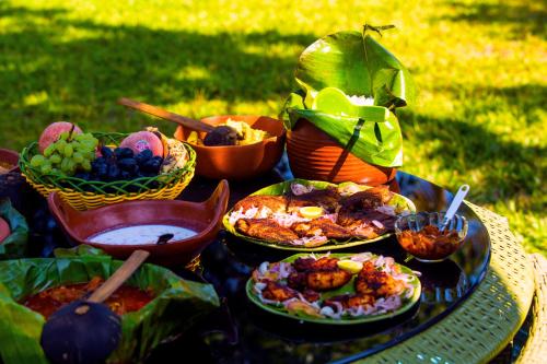 a table topped with plates of food on a table at Vinis Farm - A Private Island Stay -Privacy Redefined !!! in Munroe Island