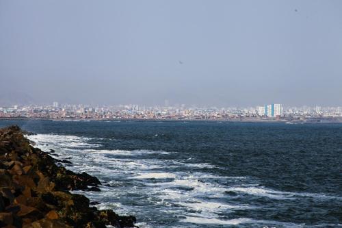 a view of the ocean with a city in the background at Villa La Punta in Lima