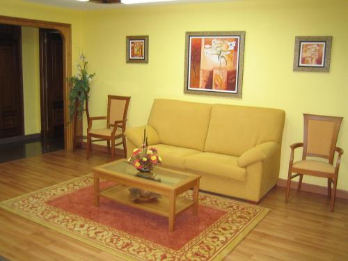 a living room with a couch and a table and chairs at Hotel Chola in Dorna