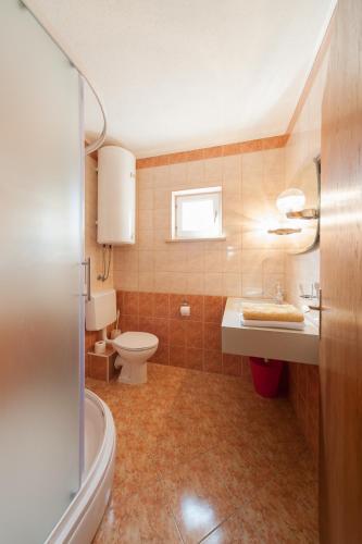 a bathroom with a toilet and a sink at Apartmenthaus Hana in Karlobag