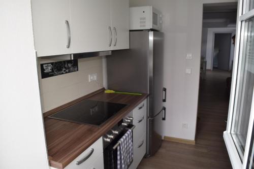 a kitchen with white cabinets and a stainless steel refrigerator at Gut Kuhfs in Großzössen
