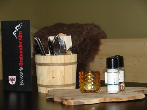 a table with a container of utensils and a candle at Brabander Alm in Biberwier