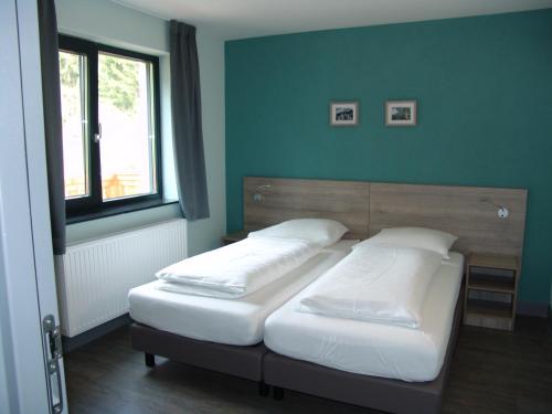 two beds in a bedroom with a green wall at Brabander Alm in Biberwier