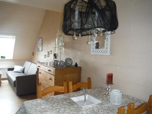 a kitchen and living room with a table and a chandelier at Maison Joseph in Hotton