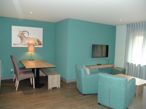a living room with a table and a blue wall at Brabander Alm in Biberwier