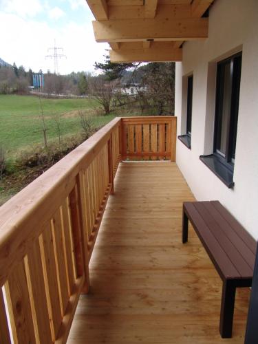 a wooden porch with a bench on the side of a house at Brabander Alm in Biberwier