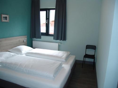 a bedroom with two beds and a chair in it at Brabander Alm in Biberwier
