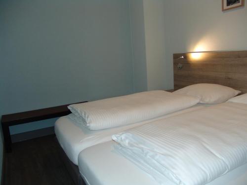two beds in a hotel room with white sheets at Brabander Alm in Biberwier