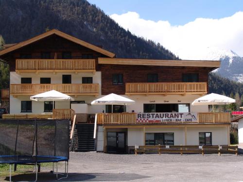 a large building with a balcony and a mountain at Brabander Alm in Biberwier