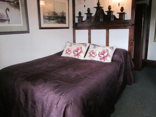 a bedroom with a bed with two pillows on it at White Owl Holiday Apartments in Robin Hood's Bay