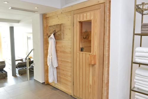 uma porta de madeira num quarto com toalhas em Naturhotel Lärchenhof em Mittelberg