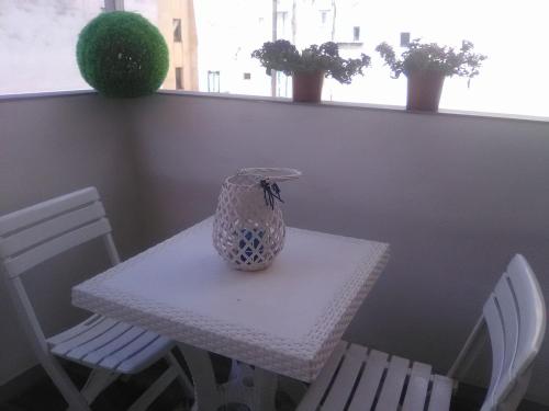 a vase sitting on a table with two chairs at Verde Mare in Trapani