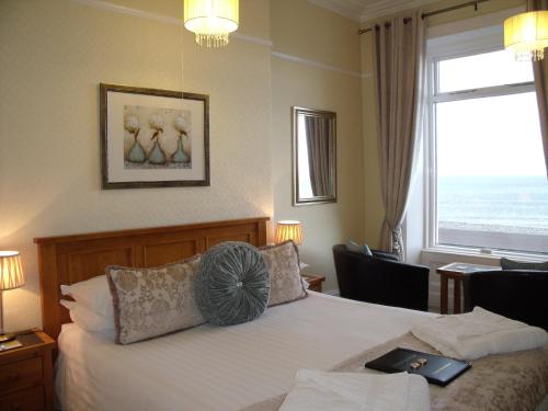 ein Hotelzimmer mit einem Bett und einem großen Fenster in der Unterkunft Britannia Guest House in Llandudno