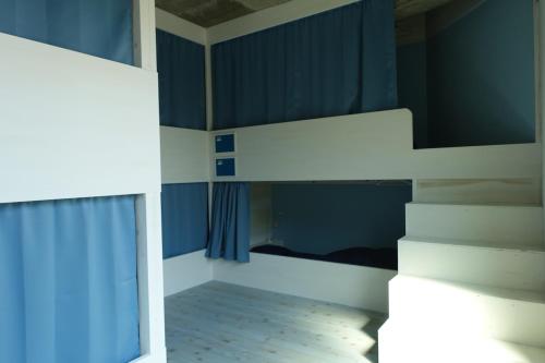 a bedroom with a bunk bed and a staircase at Hostel NABLA in Niijimamura