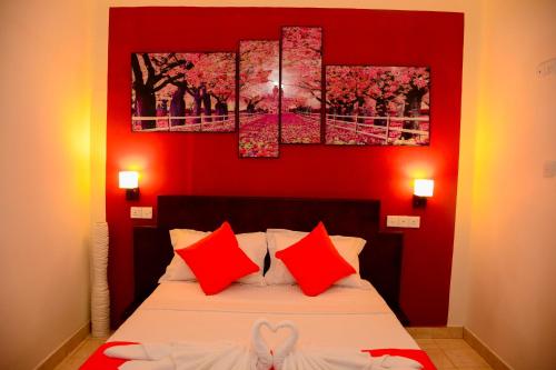 a bedroom with red walls and a bed with red pillows at Mama Beach Villa in Negombo