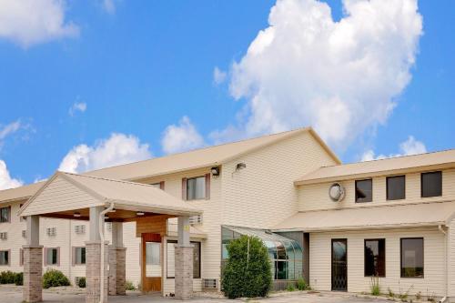 a large white building with a sky in the background at Super 8 by Wyndham Iowa Falls in Iowa Falls
