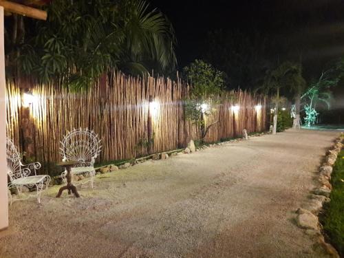 a fence with two chairs and a fence with lights at Hotel Casa Lima Bacalar in Bacalar