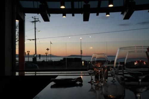 a table with glasses on it with a view of the ocean at Qualicum Beach Inn in Qualicum Beach
