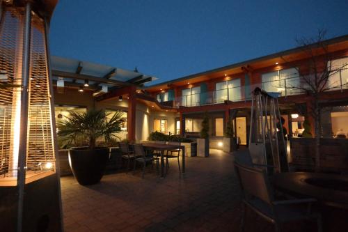a building with a patio with a table and chairs at Qualicum Beach Inn in Qualicum Beach
