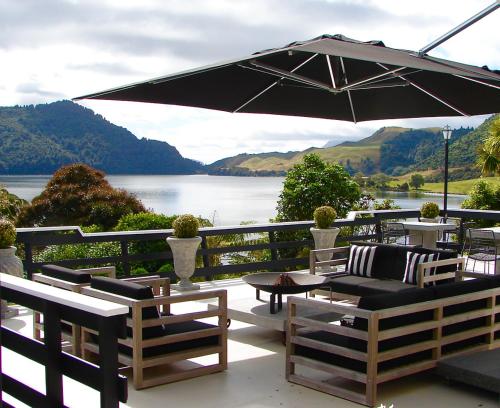 a patio with a table and chairs and an umbrella at Ngamihi Lodge in Rotorua