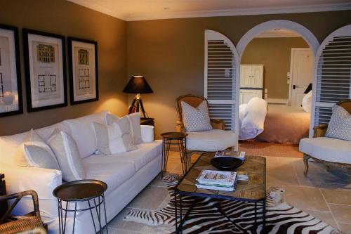 a living room with a white couch and chairs at Ngamihi Lodge in Rotorua