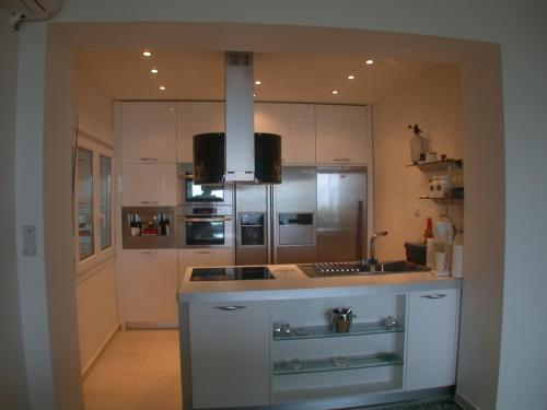 a kitchen with white cabinets and a counter top at Villa Panorama, now a Smart Home in Skala Kallirakhis