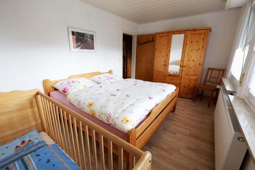a bedroom with a bed with a crib in it at Wolfsbau Ferienwohnung in Langelsheim