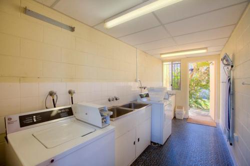 Una gran cocina blanca con fregadero y encimera. en Summit Motel en Townsville