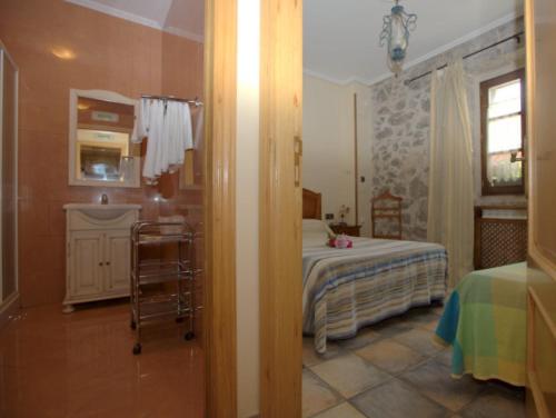 a room with a bedroom with a bed and a bathroom at Hostal Rural Elosta in Lekunberri