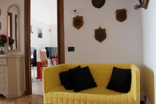 een gele bank met zwarte kussens in de woonkamer bij APT Il Rifugio del Marinaio in La Spezia