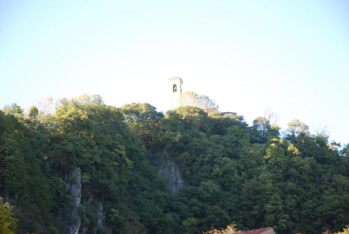 a clock tower on top of a hill with trees at Hotel Concordia in Porlezza