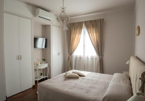 a white bedroom with a bed and a window at CasaVittorio in San Giovanni in Marignano