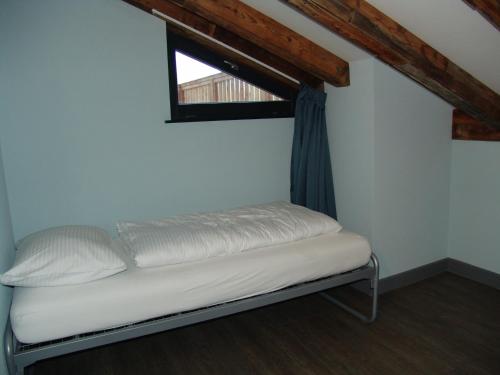 a small bed in a room with a window at Brabander Alm in Biberwier