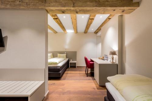 Un dormitorio con 2 camas y un escritorio en una habitación. en Hotel Gasthaus Hirschen, en Baden