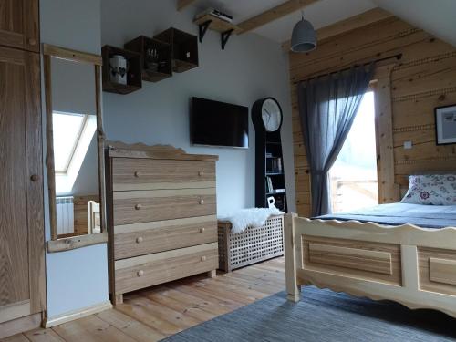 a bedroom with a bed and a dresser and a window at Domki Zawoja z Jacuzzi in Zawoja