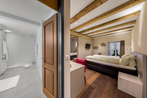a bedroom with a bed and a bathroom at Hotel Gasthaus Hirschen in Baden