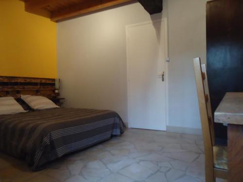 1 dormitorio con cama y puerta blanca en Le refuge du Pinail, en Vouneuil-sur-Vienne