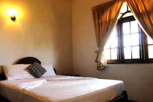 a bedroom with a bed and a window at Sujeewani Villa in Negombo