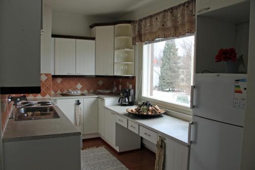 een keuken met een witte koelkast en een raam bij Vanhan Meijerin Majatalo Apartment in Varkaus