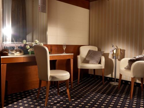 a waiting room with white chairs and a table at Hotel Ariston in Campodarsego