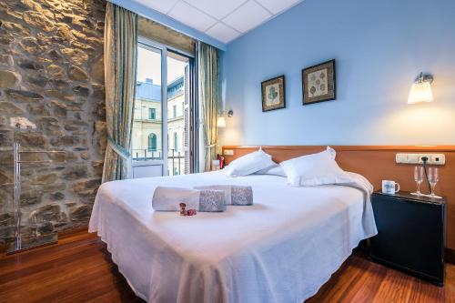 a bedroom with a large bed with two boxes on it at Pensión Ab Domini in San Sebastián