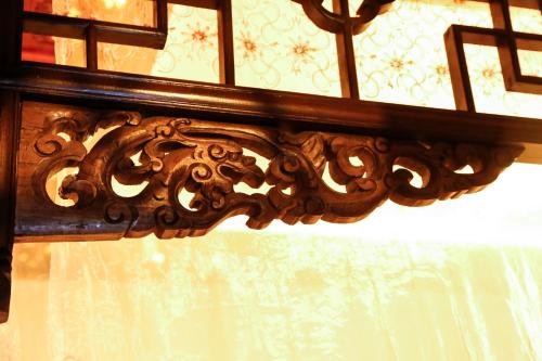 a wooden frame on a window with a curtain at Pingyao Laochenggen Inn in Pingyao