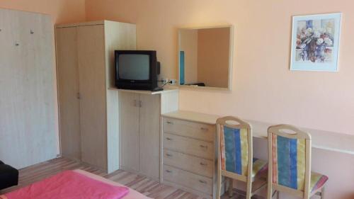 a room with a desk with a tv and two chairs at Arkadenhaus Steiner in Podersdorf am See