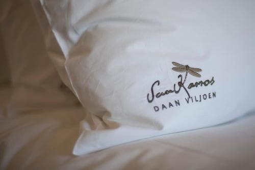 a pillow on a bed with the words scarboroughdaindaindaindaindaindain at Daan Viljoen Game Lodge in Windhoek